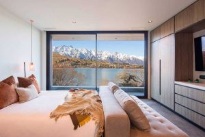 bedroom with views of lake wakatipu in queenstown. ducted heat pump vent in ceiling by campbell electric